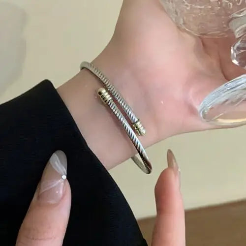 A minimalist bestseller for boutiques and gift shops. These elegant silver-tone bangles and matching thin rings feature delicate gold-tone bead accents for a subtle, two-tone contrast. A timeless, versatile set perfect for stacking or everyday wear.