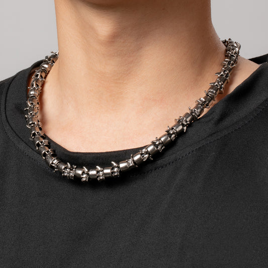 Professional male model wearing a black top with a HAWSON  Antique Metal Barrel and Vertebrae Necklace