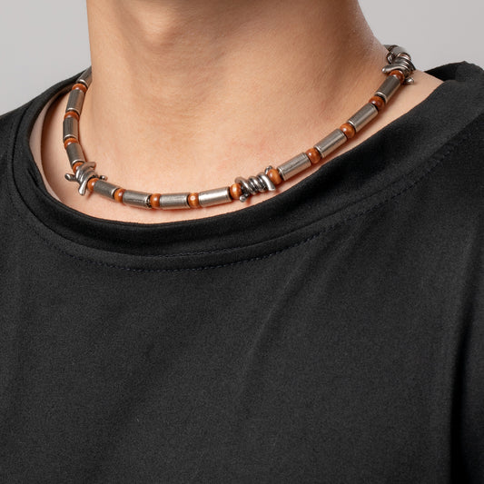 Professional male model wearing a black top with the HAWSON cylindrical barrel and tiger eye bead wire necklace