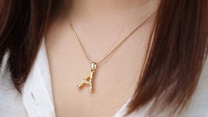 Gold-tone initial pendant necklace worn for a personalized everyday look