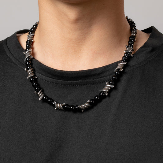 Professional male model wearing a black top and the HAWSON bike barbed wire necklace