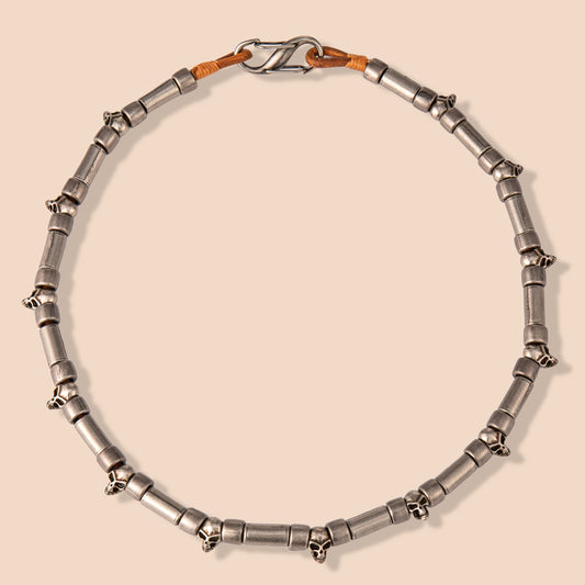 HAWSON vintage skull necklace with rotating cylindrical links and distressed stainless steel finish, blending Victorian industrial aesthetics with gothic edge